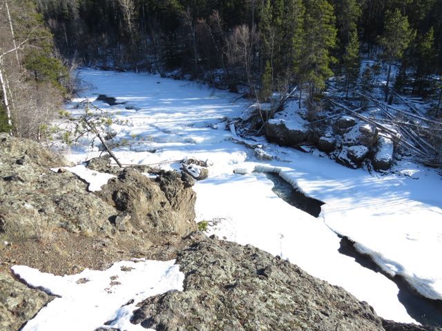 frozen river near waterfall